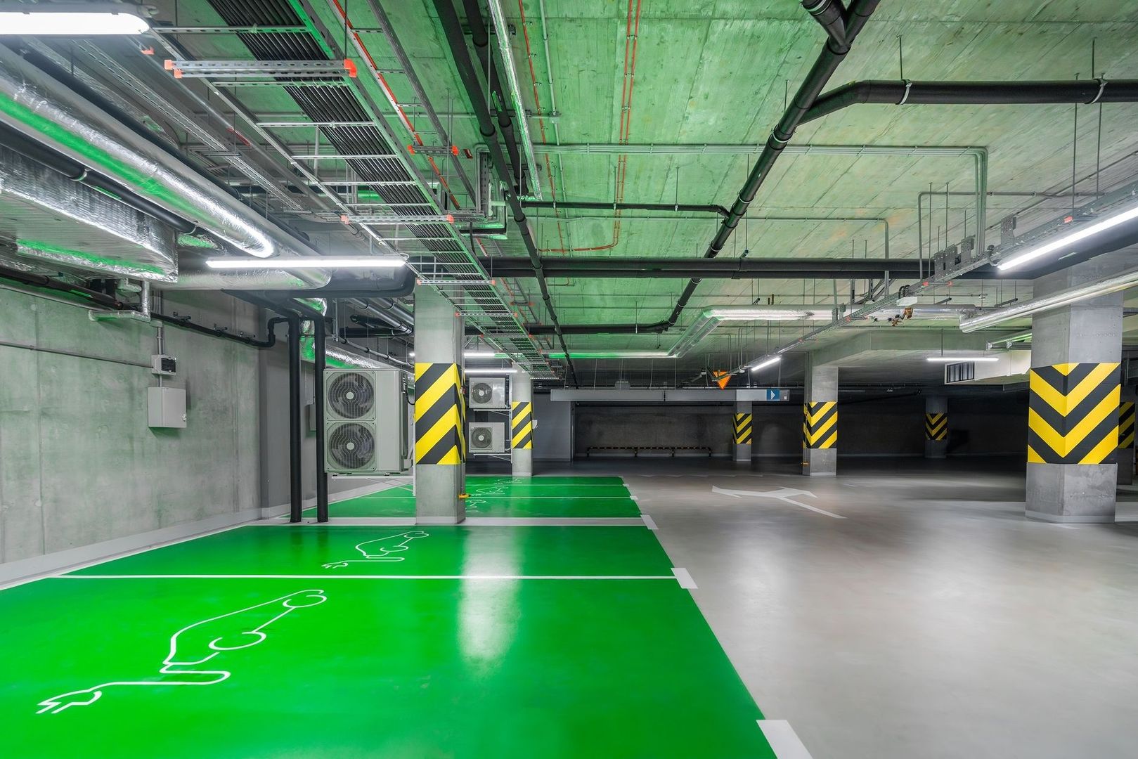 Underground garage with green-marked electric vehicle parking bays