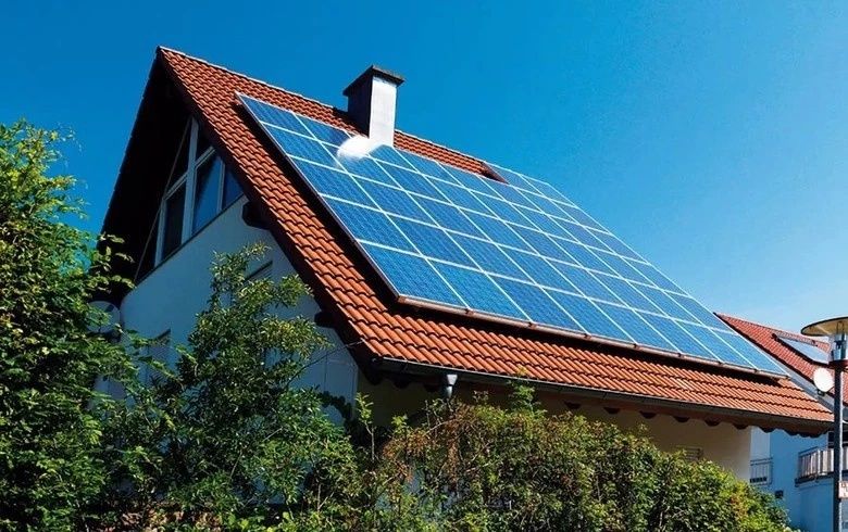 Solar panels installed on the red-tiled roof of a residential house